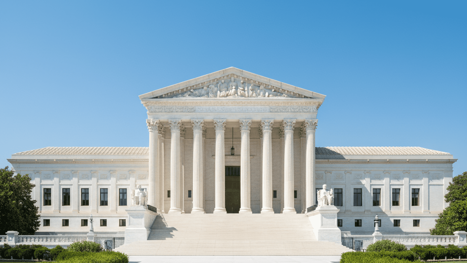 The Supreme Court building in Washington, D.C. stands under a clear blue sky.