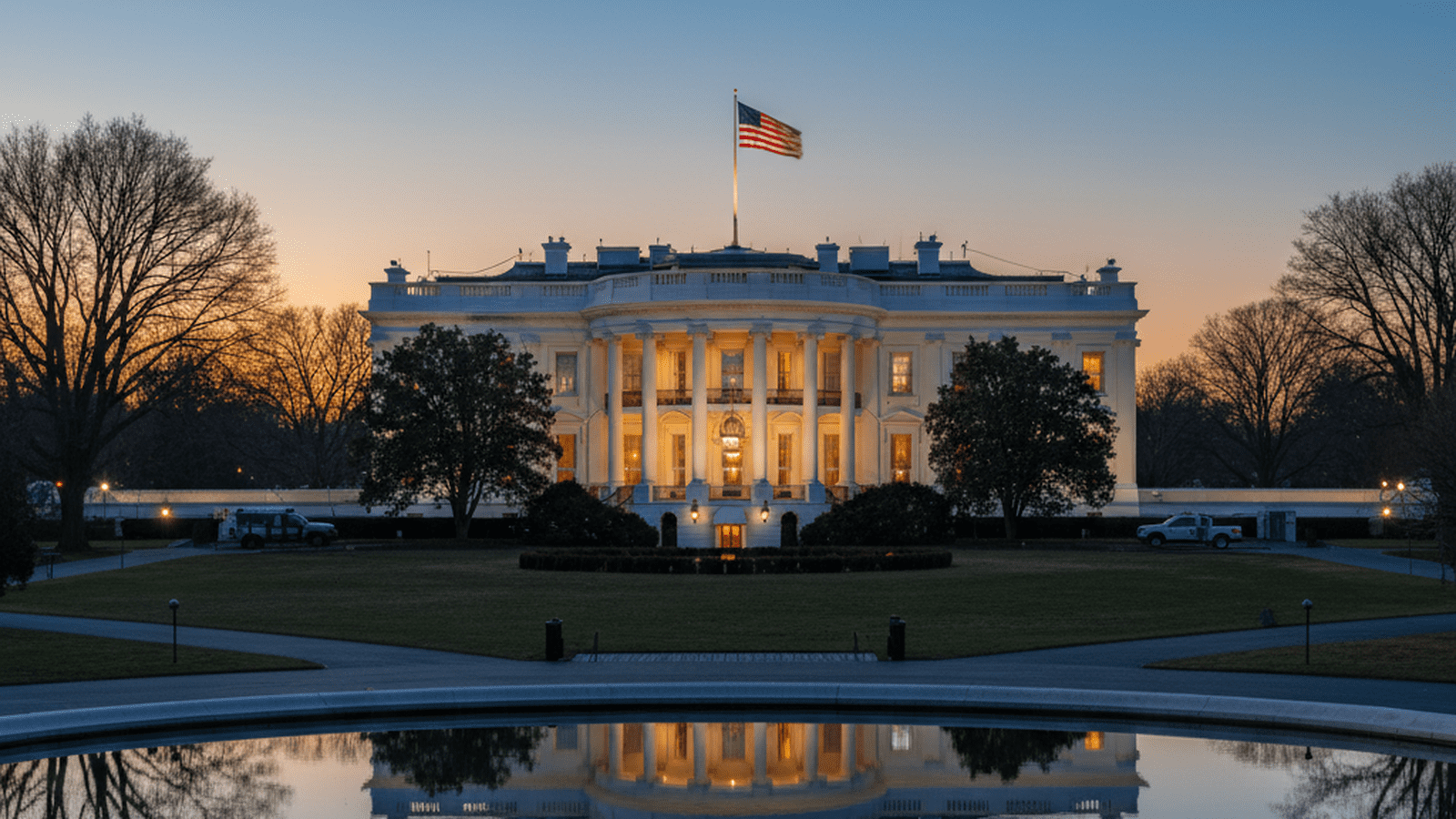 The White House at dusk with the American flag flying.