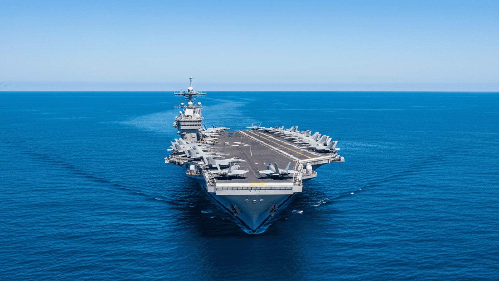 The USS Gerald R. Ford aircraft carrier sails through the ocean as part of a military buildup in the Middle East.