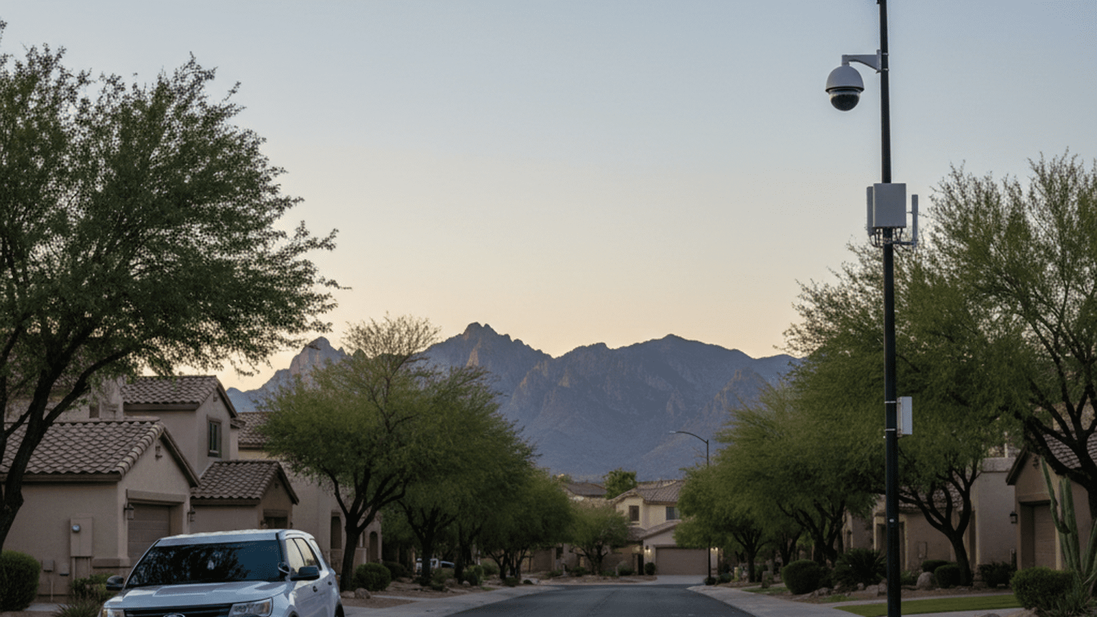 A Pima County Sheriff's vehicle sits on a quiet Tucson street near a pole equipped with surveillance cameras and cellular data equipment.