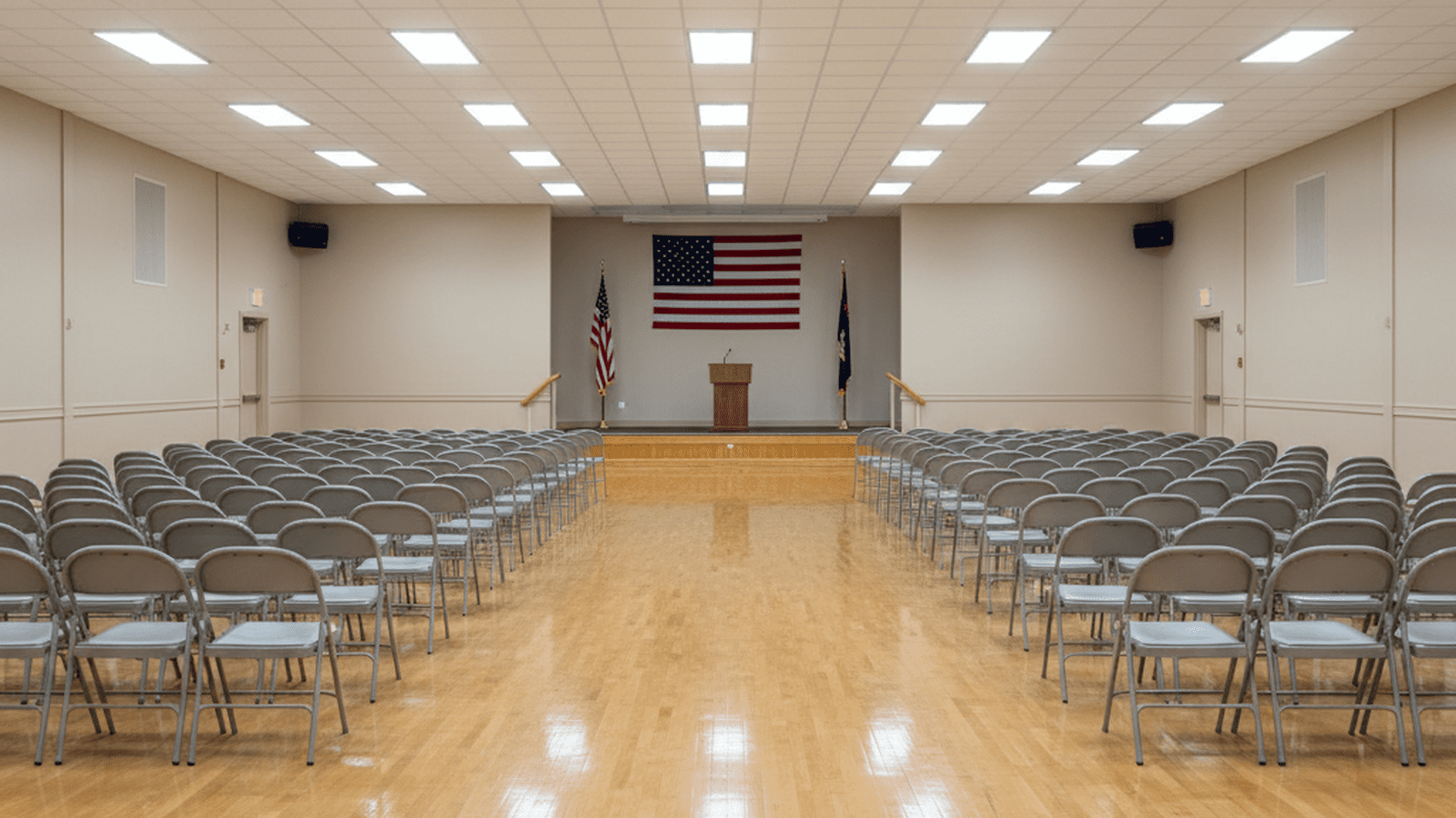 An empty, well-lit American Legion hall prepared for a community meeting.