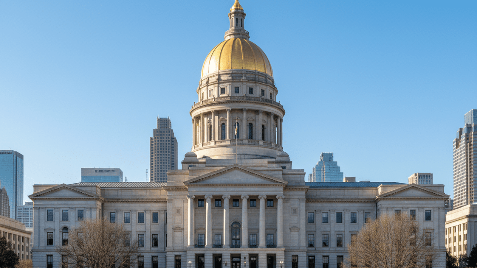 The Georgia State Capitol building stands prominently in Atlanta under a bright sky.