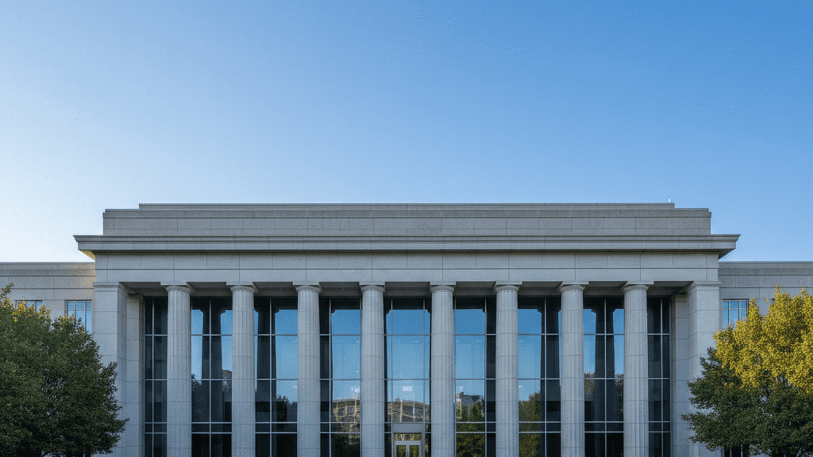 A sturdy stone federal courthouse stands under a clear sky, representing the strength of the law.