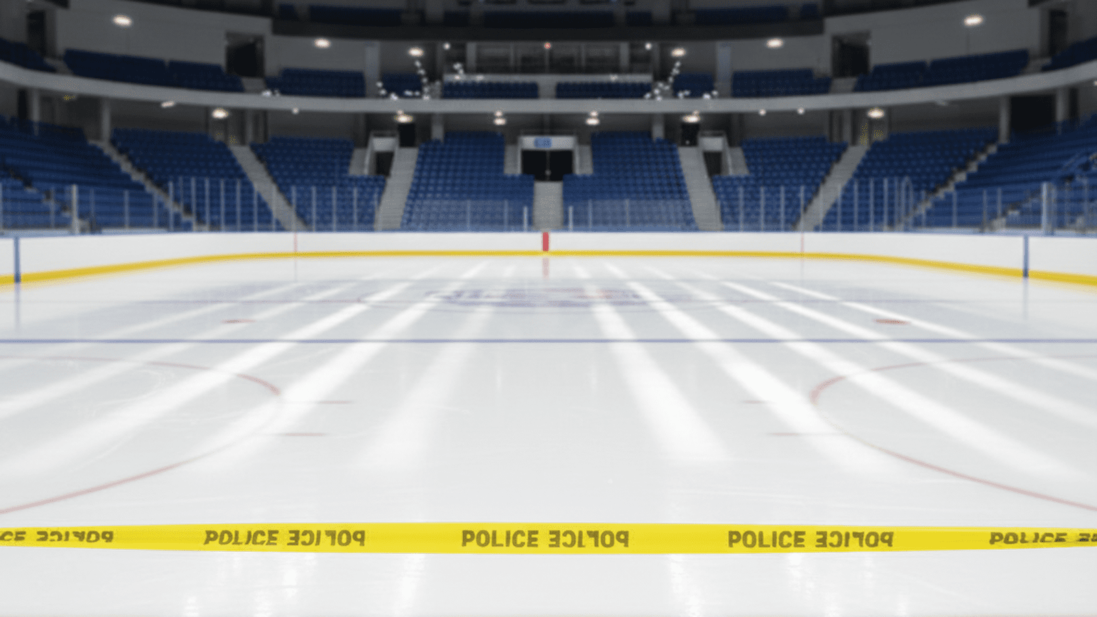 An empty ice hockey rink is framed by yellow police tape in a quiet, well-lit arena.
