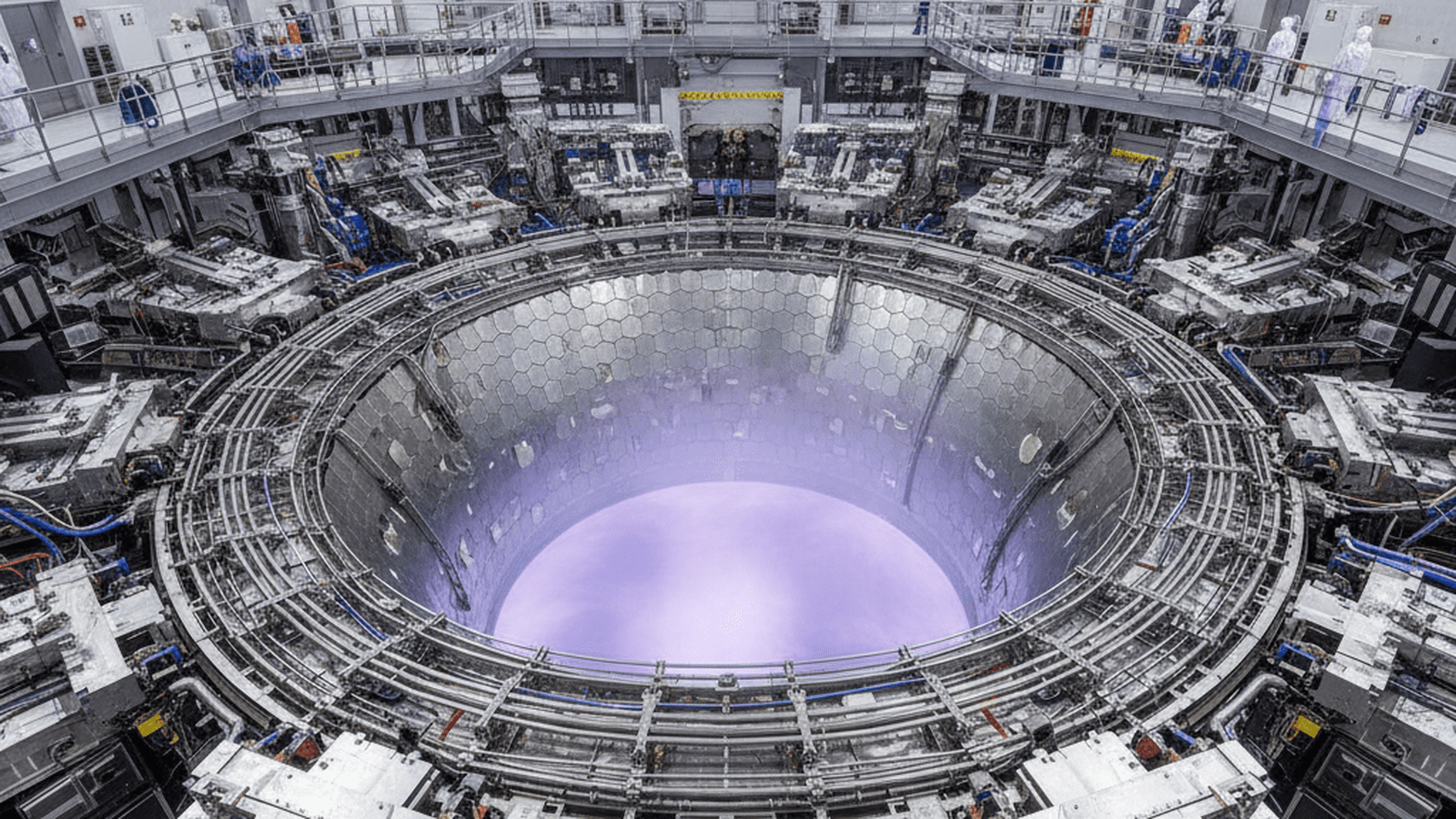 The interior of the JT-60SA tokamak showing the vacuum vessel and the purple glow of a plasma discharge.