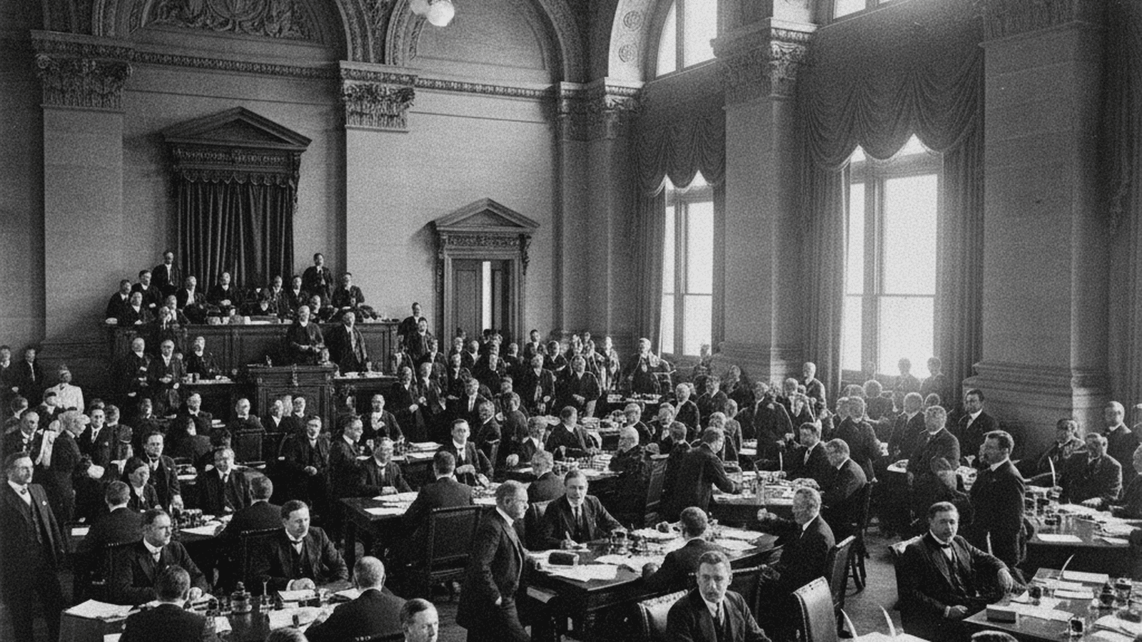 A black and white historical photograph of the New York State Senate chamber during a legislative session in 1910.
