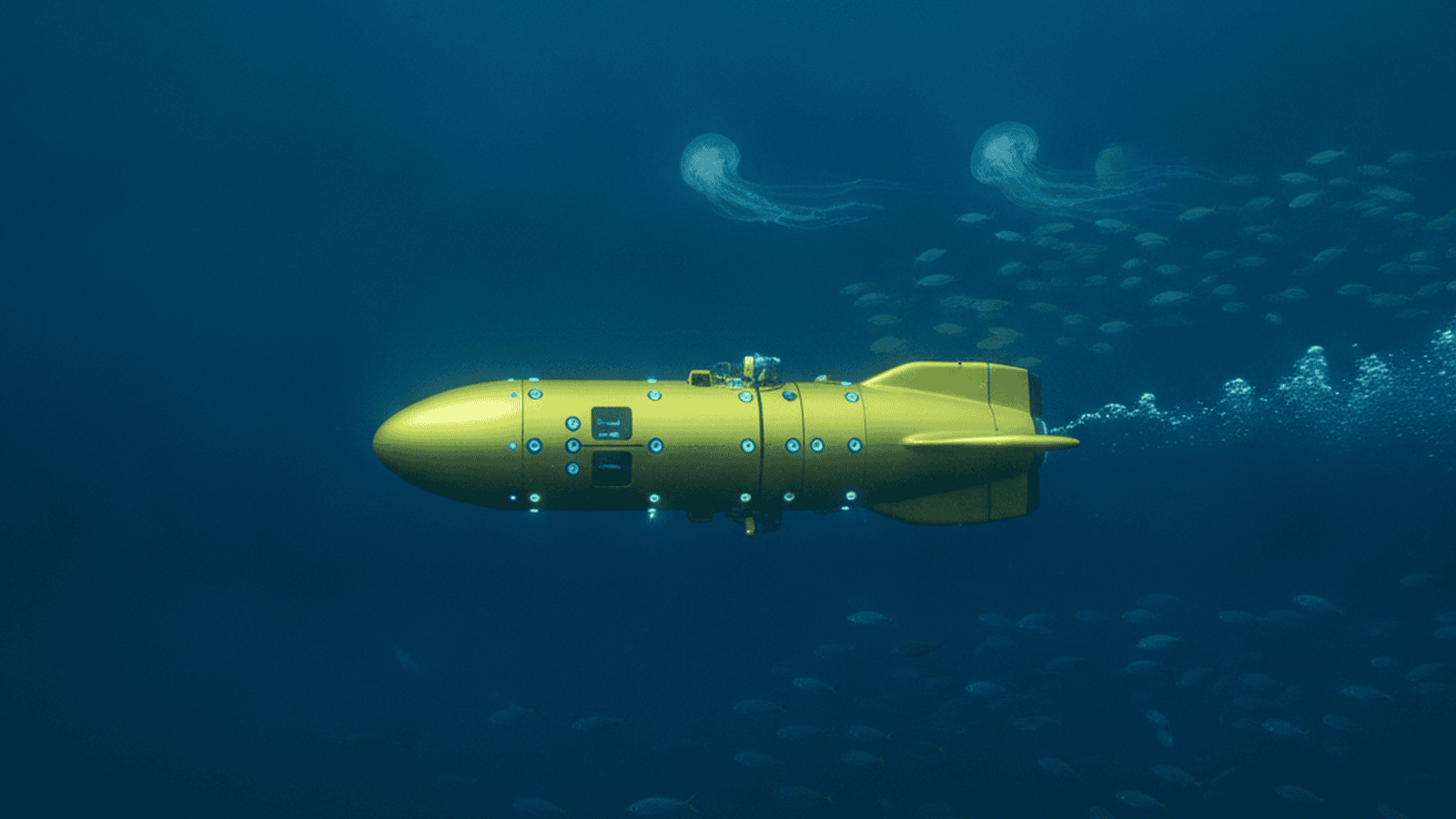 A yellow autonomous underwater vehicle moves through the deep blue ocean, surrounded by marine life.