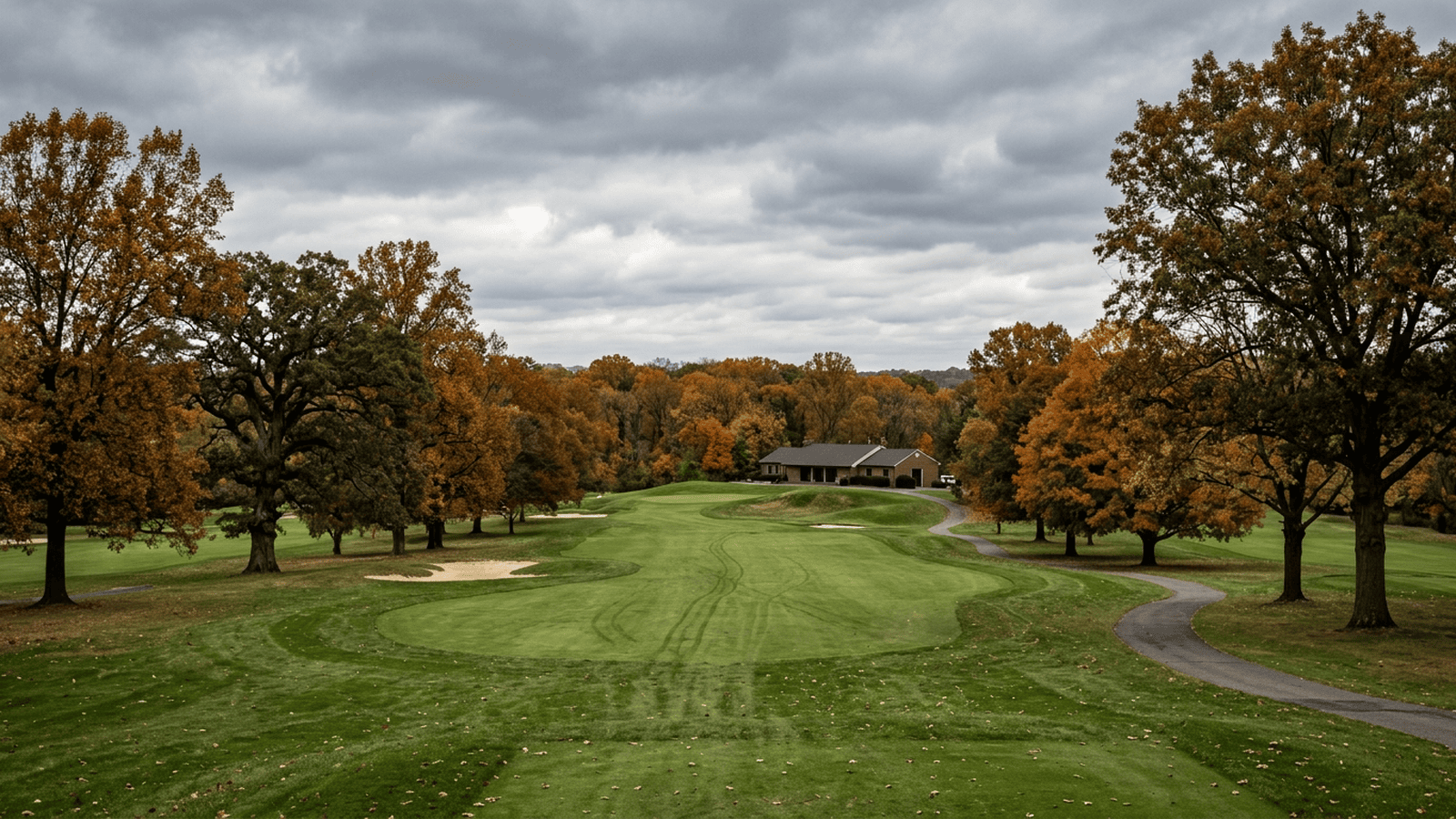 A tree-lined public golf course in Washington, D.C., with a fairway and clubhouse beneath an overcast sky.