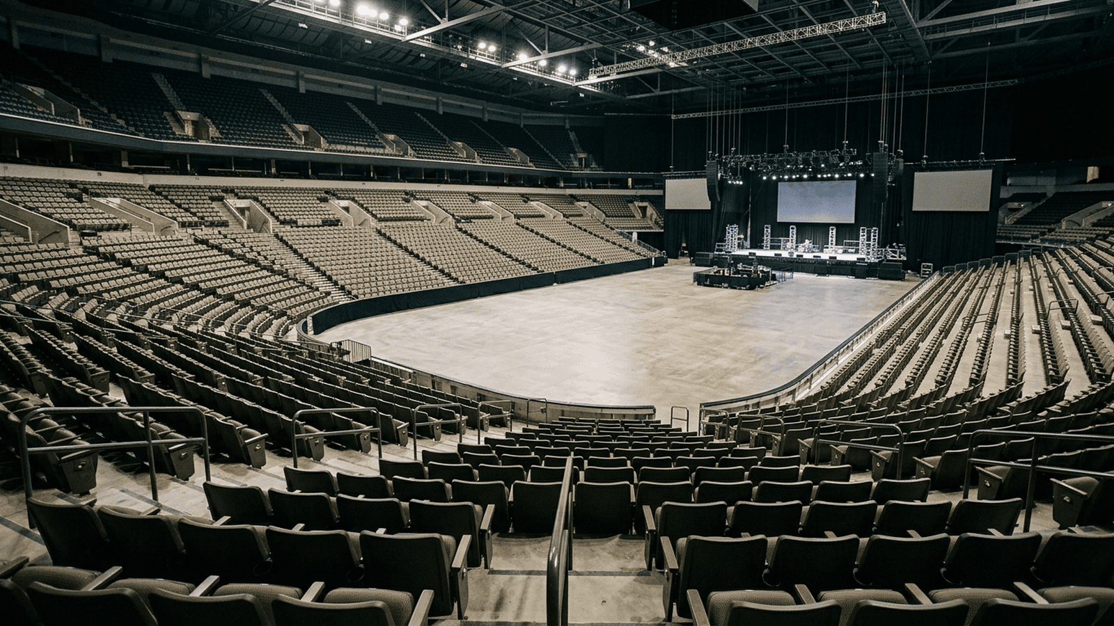 An indoor arena with rows of seats and a distant stage after a political rally.