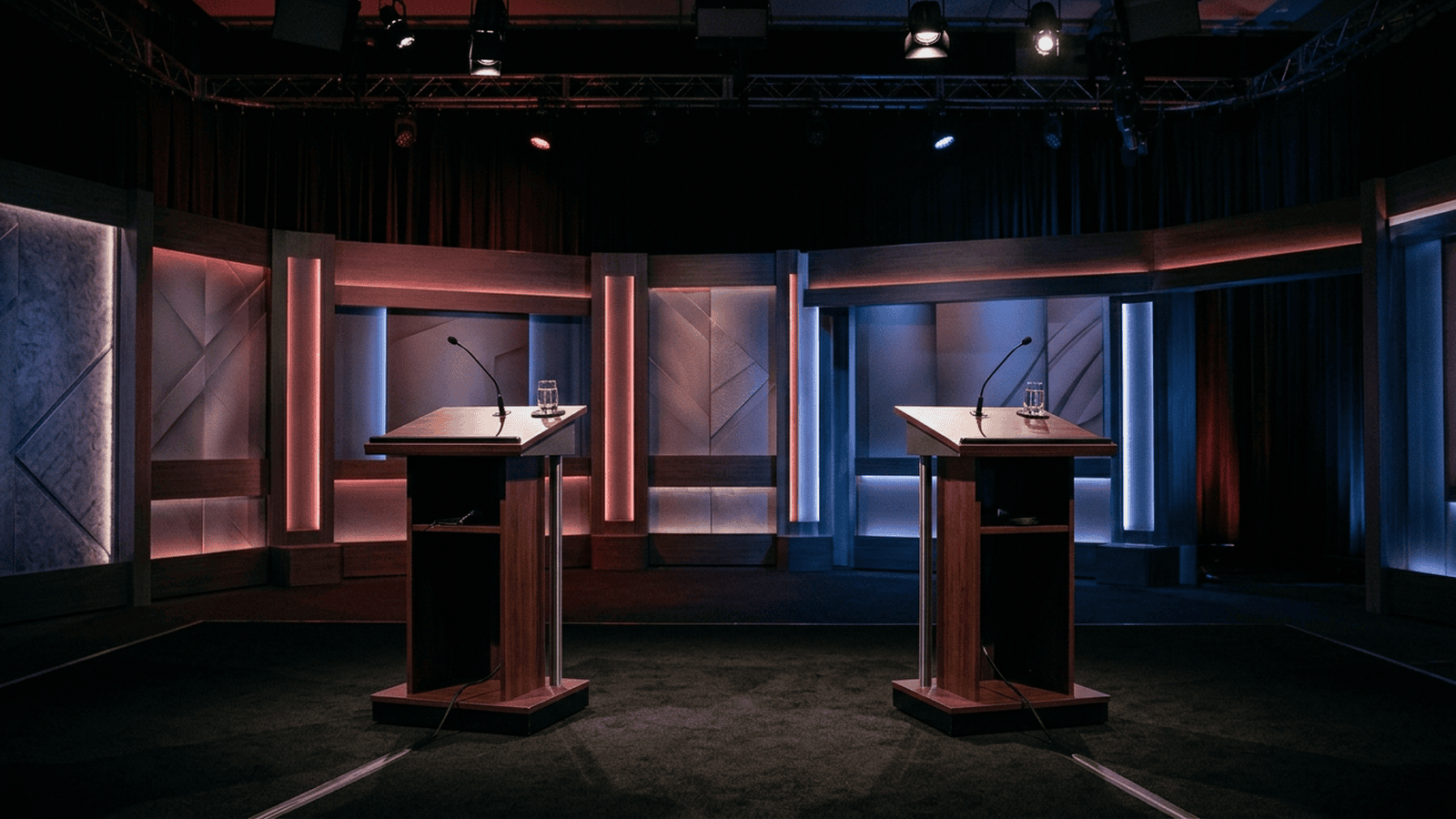 Two empty lecterns stand on a debate stage prepared for the final Michigan Senate debate.