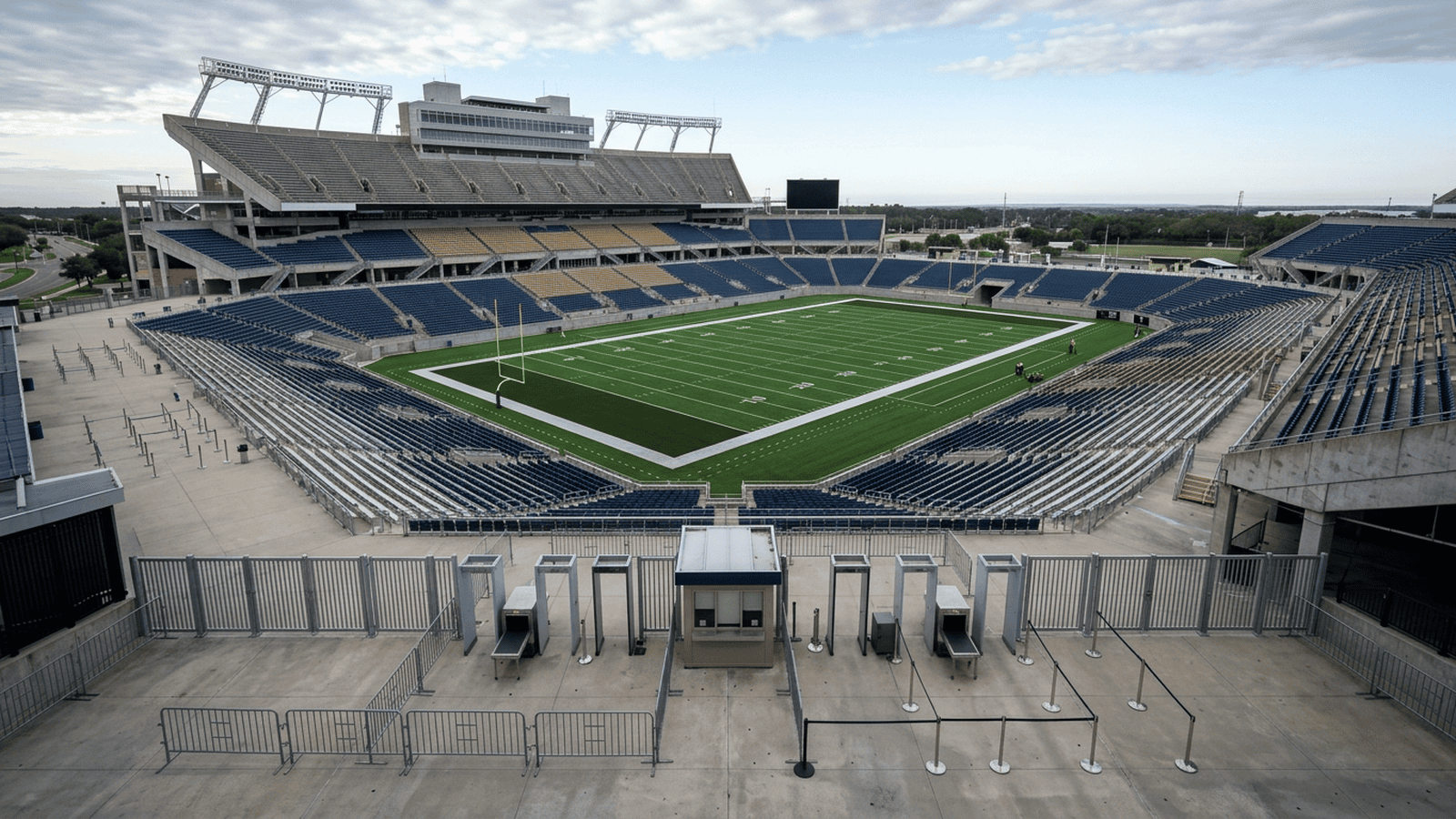 An empty football stadium with a security checkpoint near the stands.