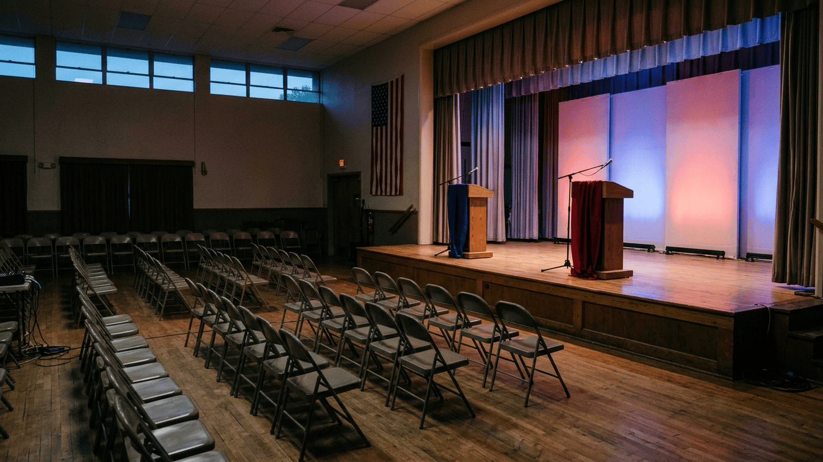 An empty rally venue with two lecterns and rows of chairs represents the competing campaigns in the Senate races.