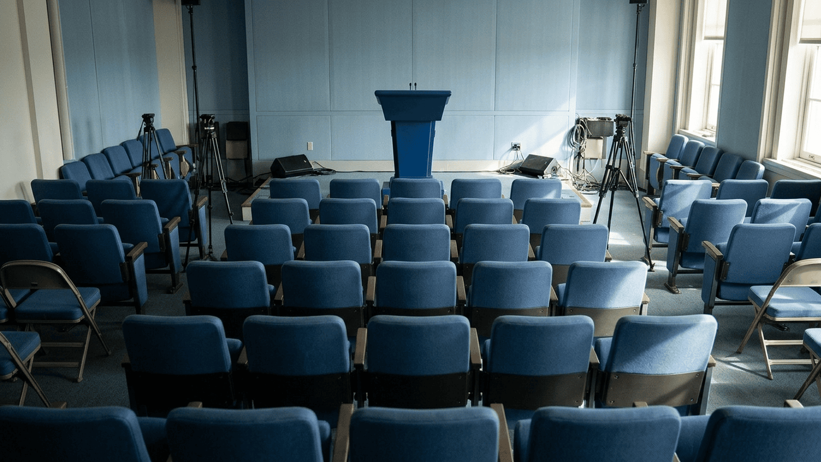 An empty White House briefing room with rows of seats facing a lectern.