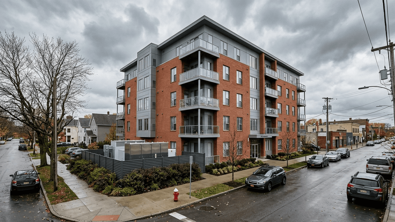 An apartment building in Buffalo stands beside a utility enclosure representing its large battery storage system.
