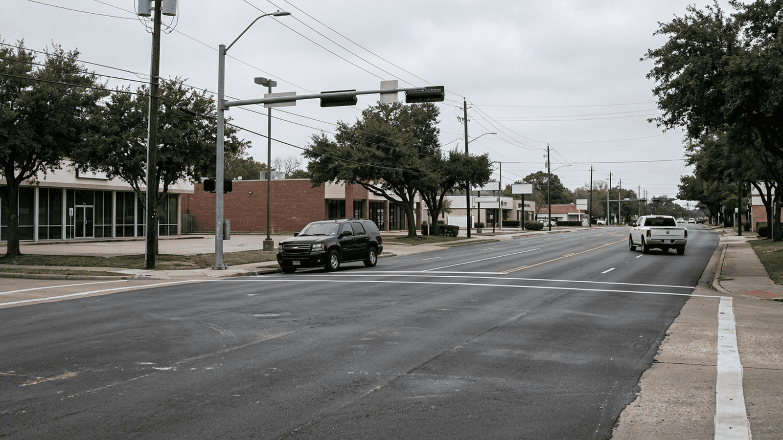 A dark SUV and a white pickup truck are visible on a Houston street.