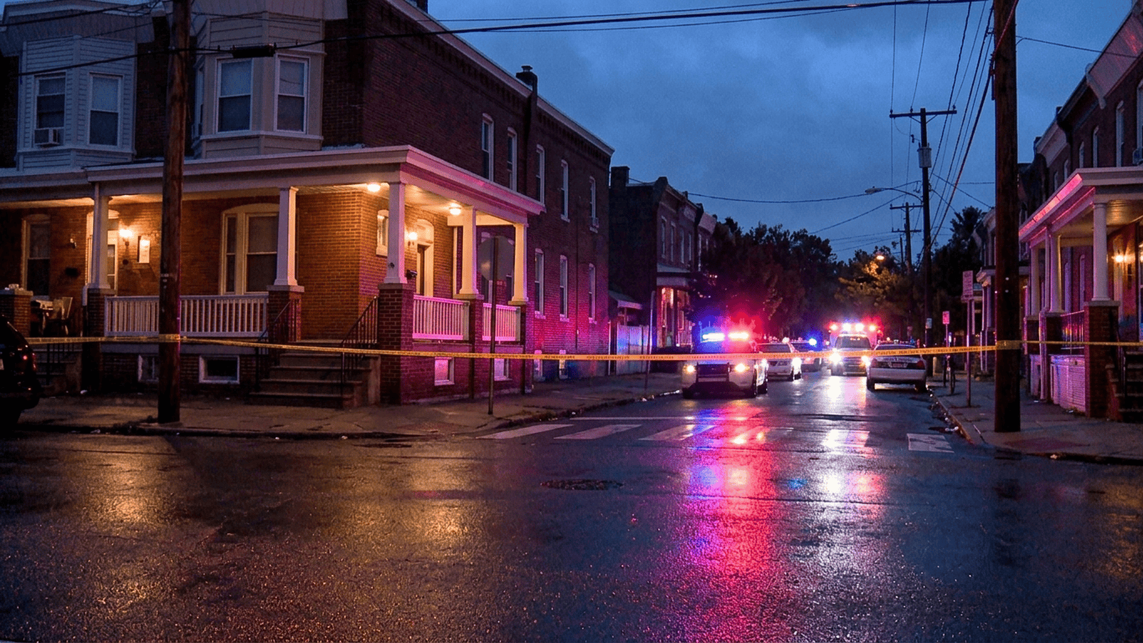 Emergency lights illuminate a residential street in West Philadelphia at night.